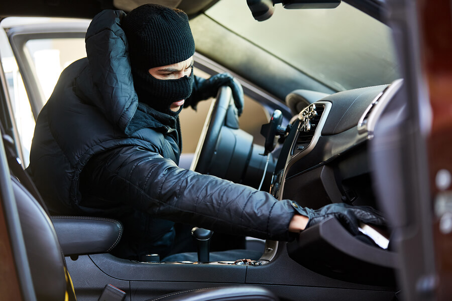 Thief-in-the-car-rummages-through-glove-compartment-for-garage-door-remote