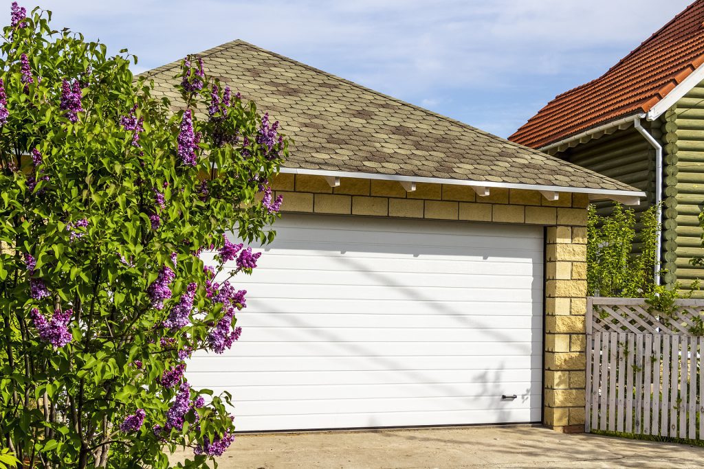 White-Garage-Doors-of-a-Private-House-and-Nearby-Lilac-Bushes
