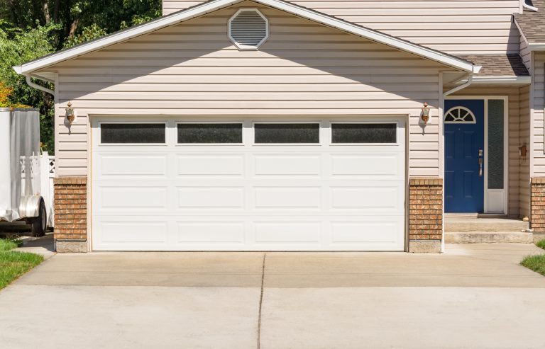 Wide-Garage-Door-Of-Residential-House-with-Concrete-Driveway-in-Front-