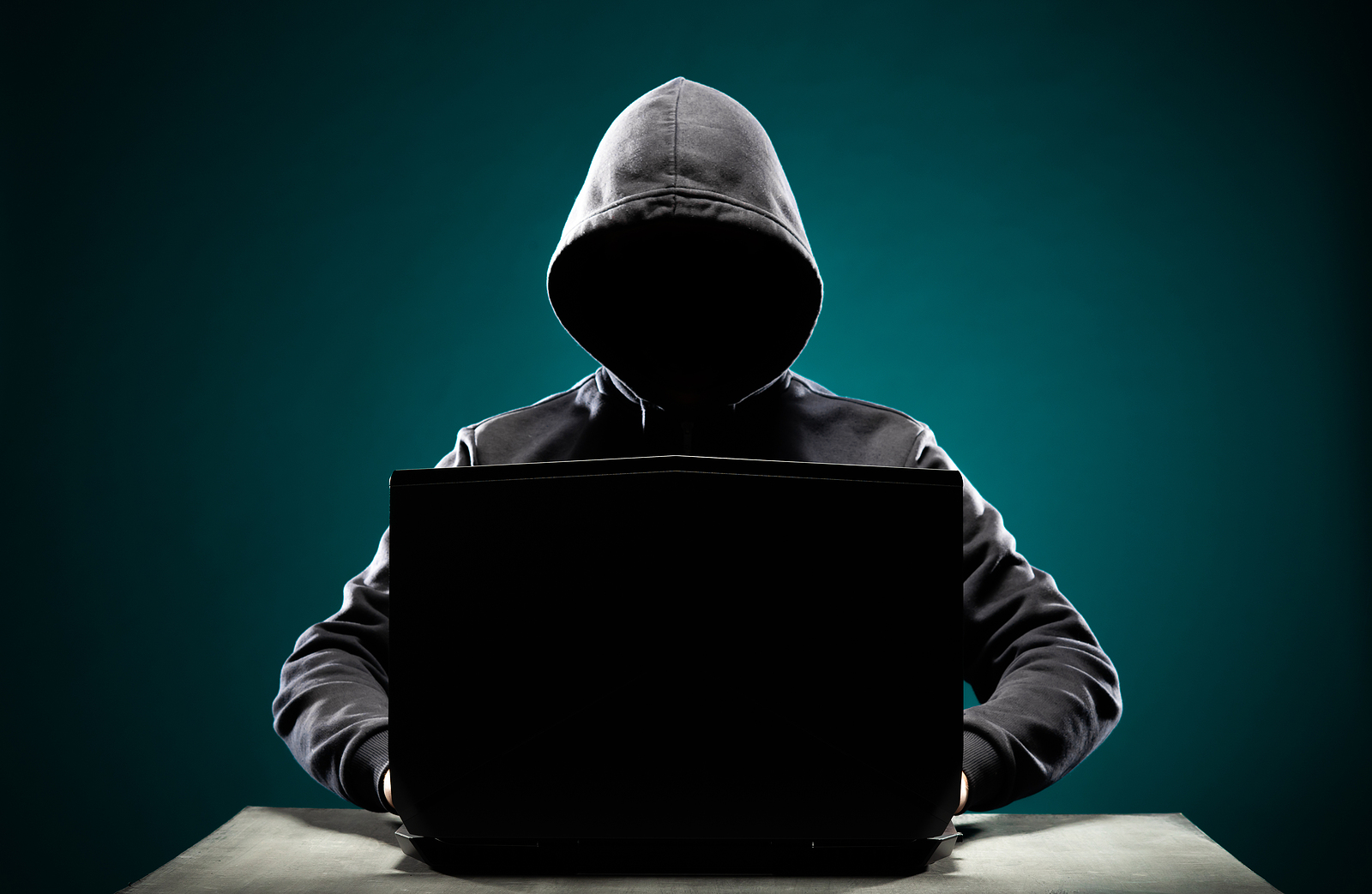 Computer-Hacker-In-Hoodie-Sweater-with-Obscured-Face-Using-Laptop