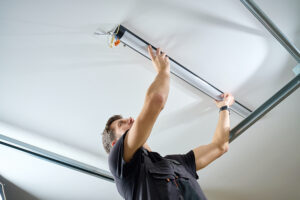 Homeowner replacing a garage door opener light bulb