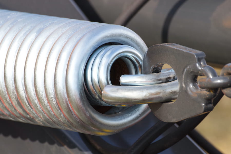 Compare torsion spring vs extension spring systems to learn how garage door springs work, their differences, benefits, safety, and maintenance needs.